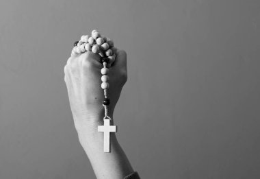 Genç bir kadın elinde tespihle dua ediyor. 