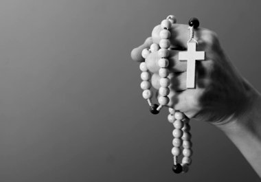 Genç bir kadın elinde tespihle dua ediyor. 