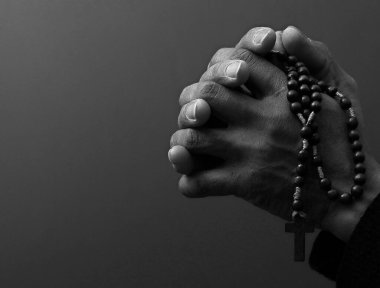 Afro-Amerikan bir adam siyah arka plan için tespih çekiyor. 