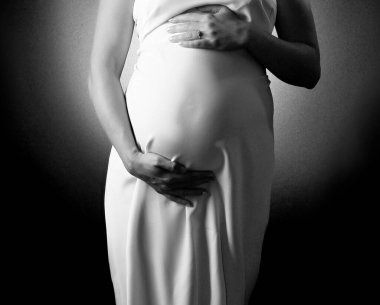 Beyaz elbiseli hamile kadın.