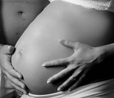 Elleri karnında hamile bir kadın.