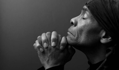 Gözleri kapalı bir Hıristiyan stüdyoda karanlık arka plan için dua ediyor. kopyalama alanı konsepti. siyah beyaz fotoğraf 