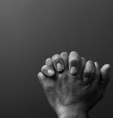 Hıristiyan adam stüdyoda karanlık arka plan için dua ediyor. siyah ve beyaz, kırpılmış fotoğraf 