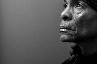 Yetişkin bir adam stüdyoda karanlığa karşı dua ediyor. Alan arkaplanını kopyala 