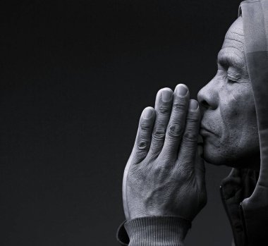 Hıristiyan adamın dua ettiği siyah beyaz bir fotoğraf. 