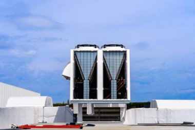 Multizon klima ve havalandırma sistemi. Büyük bir sanayi binasının çatısındaki açık hava birimleri. Endüstriyel havadan suya soğutucular