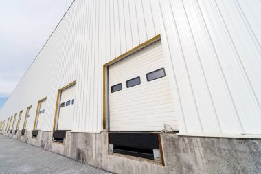 Bölgesel depo kapısı dağıtılmış bir merkeze yükleme ve boşaltma için. Kamyonlar için yükleme ve boşaltma alanları. Bir sanayi binasının inşaatı