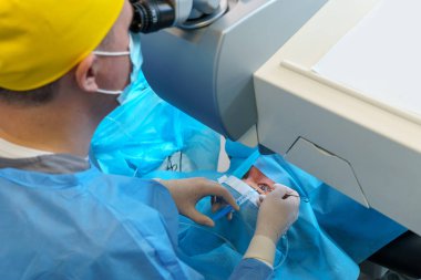 Cerrah ellerinin yakın plan çekimi cerrahi bir işlem sırasında gözünüze enjekte edilecek. Hassas araçlar ve steril kurulum güvenliği sağlar