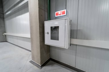 Duvara monte edilmiş sanayi yangın güvenlik kabini. Yukarıda acil durum alarmı var. Yangın durumunda hızlı bir giriş ve görüş alanı sağlıyor.