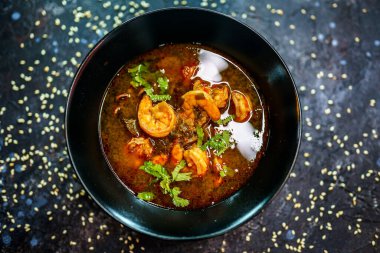 Deniz ürünleri çorbası, karides, kalamar ve taze kişniş, deniz ürünleri aşıkları için baharatlı ve lezzetli bir çorba.