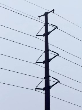 Mavi gökyüzüne karşı elektrik direği.