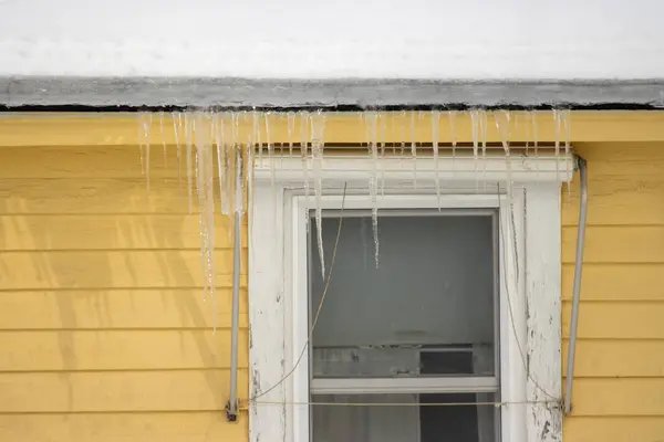 Çatıda buz saçakları var. Kış manzarası