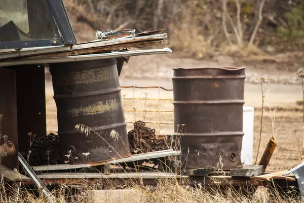 a rusty metal barrel on the ground