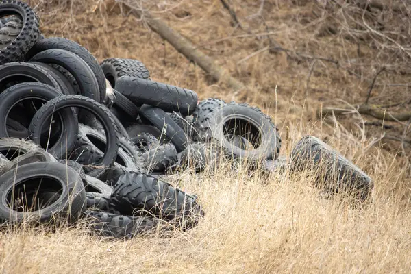 Çimenli yamaçta atılmış lastik yığını