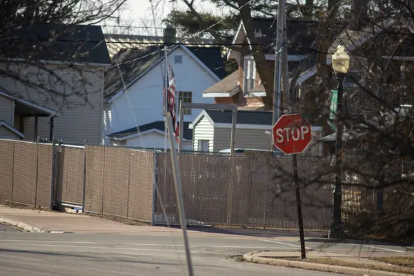 Arka planda çit olan bir şehir caddesinin dikey görüntüsü.