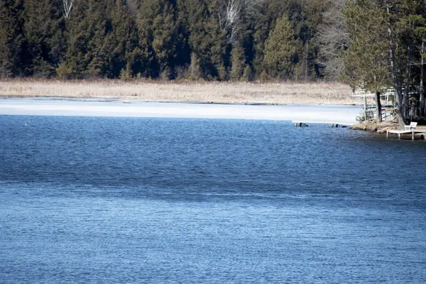 Kar ve buzla kaplı bir gölün kış manzarası