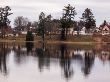 Ev gölün ortasında göleti olan küçük bir kasaba. Ev ağaçlarla çevrili..