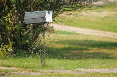 Yeşil çimlerin üzerinde beyaz posta kutusu
