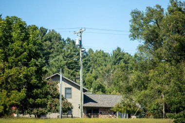Ağaçlarla çevrili tahta bir evin dikey görüntüsü.