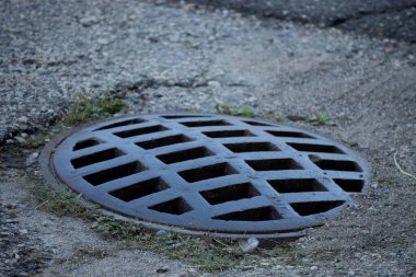 Caddenin yüzeyinde bir kanalizasyon ızgarası