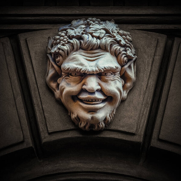 Защитная маска на вершине исторического входа в здание, барельеф Сатыра