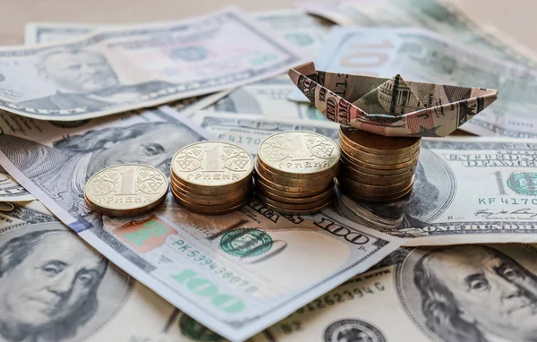 stock image Dollar bills laid out on the table. A dollar boat on the smallest column of coins, four columns of coins, savings, salary, bank, Ukrainian kopecks, Ukrainian money, hryvnia. Photo, macro photography