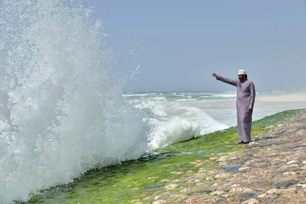 Local man watching the surf at the corniche of Salalah during the monsoon season, or Khareef season, Salalah, Dhofar region, Orient, Oman, Asia