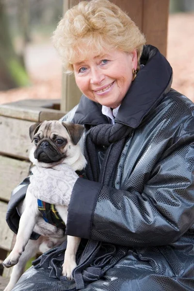Senior Holding Her Young Pug Her Lap — Stock Photo, Image