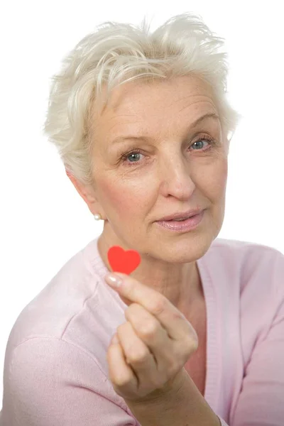Μια Ώριμη Γυναίκα Που Κρατάει Μια Κόκκινη Καρδιά Ανάμεσα Στα — Φωτογραφία Αρχείου