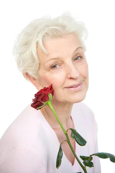 Взрослая Женщина Держащая Красную Розу Лице — стоковое фото