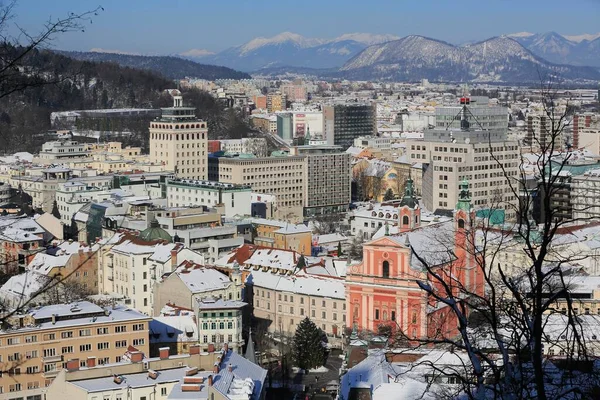 城市景观 有方济各会教堂和摩天大楼 后面是卡拉万肯山脉 冬季从卢布尔雅那城堡俯瞰 斯洛文尼亚卢布尔雅那 — 图库照片