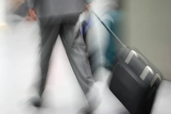スーツケースを着たビジネスマンがぼやけた眺め — ストック写真