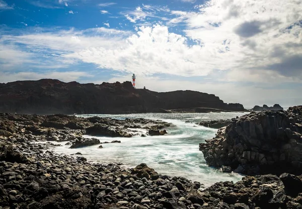 Spiaggia Con Pietre Laviche Nere Mare Turchese Sul Retro Faro — Foto Stock