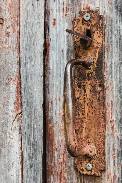 古い木製の灰色と赤塗装納屋のドア 背景画像上の錆びた金属ハンドルのクローズアップ — ストック写真