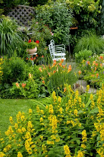 Kwitnący Ogród Lecie Część Wypoczynkowa Ogrodzie Białymi Krzesłami — Zdjęcie stockowe