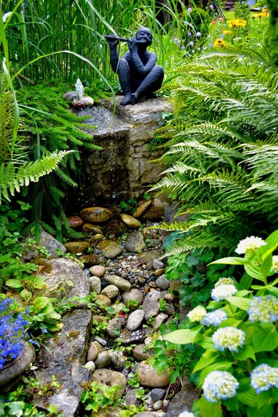 Figura Jardín Negro Con Flauta Transversal Hortensias Floreciendo Junto Arroyo — Foto de Stock