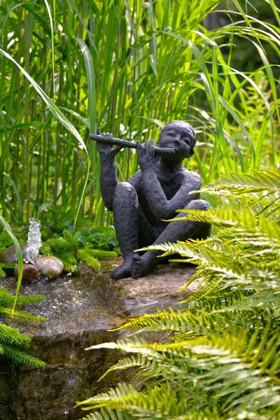 Garden figure with flute at the fountain