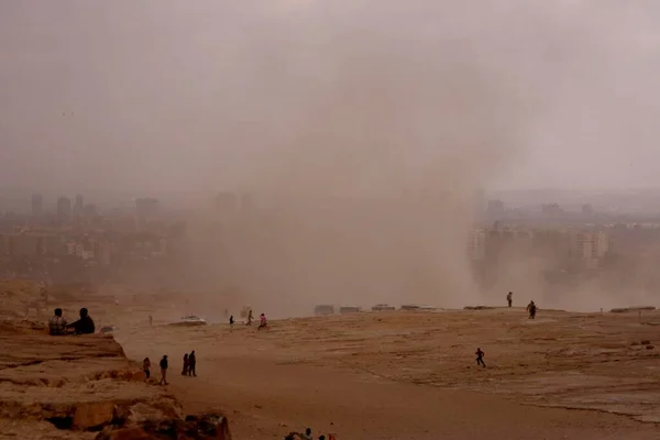 強力な風船がギザ エジプト アフリカのピラミッドで観光客の間の塵を駆動する — ストック写真