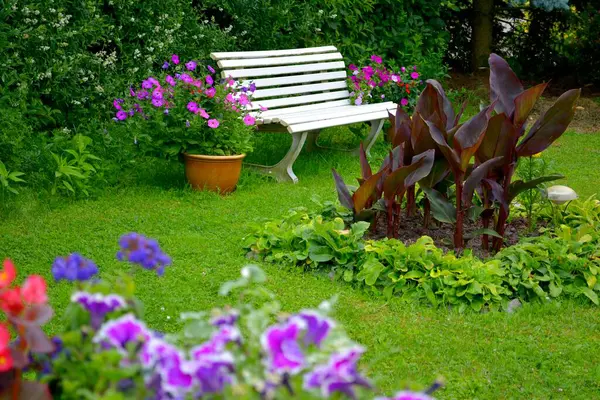 White garden bench in the flower garden