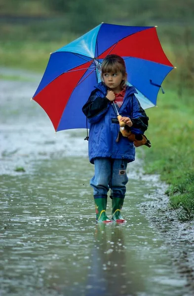 Mała Dziewczynka Parasolem Gumowymi Butami Stojąca Ogromnej Kałuży Deszczu Deszczową — Zdjęcie stockowe