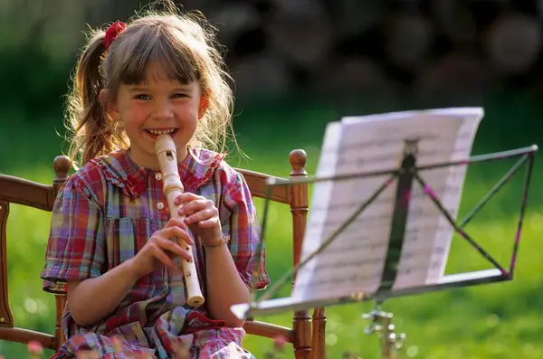 Little Girl Playing Flute Uit Bladmuziek Muziekstandaard — Stockfoto