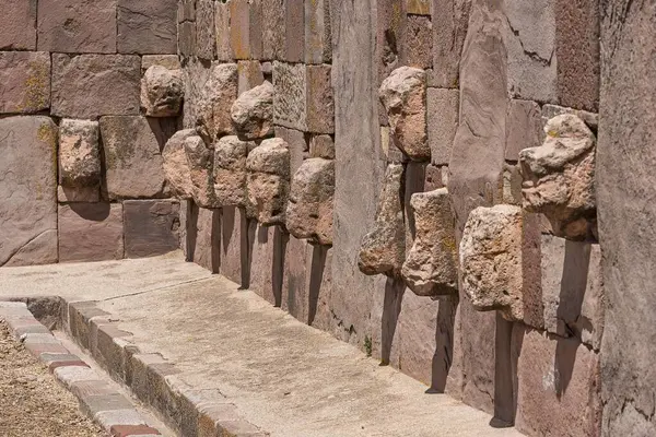 Stone heads in wall of Kalasasaya temple (place of standing stones) with monoliths from pre-Inca period, UNESCO world heritage site, Tiahuanaco, Bolivia, South America
