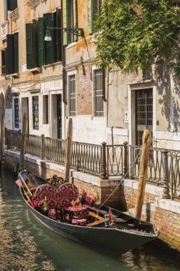 Moored gondola with heart-shaped pillow on narrow canal lined with historical architectural residential buildings, Fondamenta de l'Osmarin, Castello district, Venice, Veneto, Italy, Europe clipart