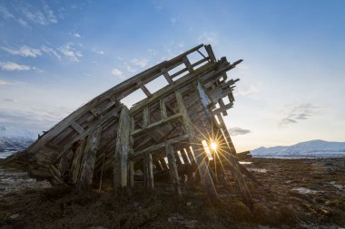 Shipwreck at sunrise and low tide near Tisnes Peninsula, Tromsoe, Norway, Europe clipart