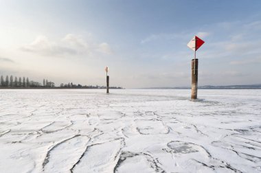 Navigation mark on a frozen Lake Constance with skaters, island auf Reichenau, Konstanz district, Baden-Wuerttemberg, Germany, Europe clipart