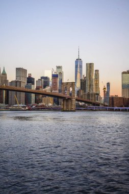 Brooklyn Bridge at sunrise, view from Main Street Park over the East River to the skyline of Manhattan with Freedom Tower or One World Trade Center, Dumbo, Downtown Brooklyn, Brooklyn, New York clipart