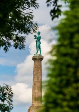 Belgrad, Sırbistan - 9 Mayıs 2024: Belgrad 'ın turistik merkezi Victor Anıtı ağaçların arasından görülüyor. Seyahat ve turizm eğitimi için elverişli.