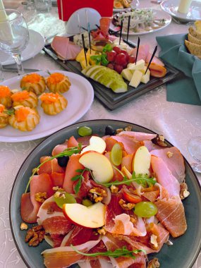 Aperatiflerle ziyafet masası, et karışımı, şarap, tabak, bardak aperatifleri.