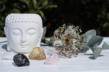 Buda heykeli ve doğal minerallerle sunak. Morion, sitrine ve gül kuvars kutsal yerde.