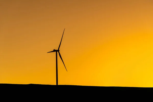 日落时站在山上发电的风力涡轮机 — 图库照片